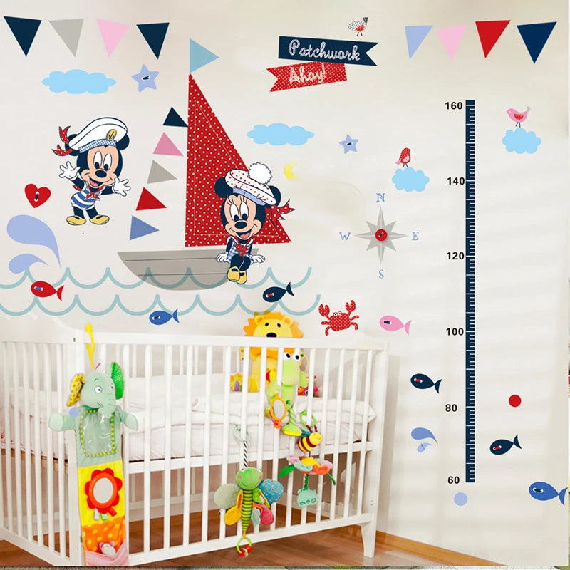 Children's room with nautical-themed wall decals, crib, and growth chart.