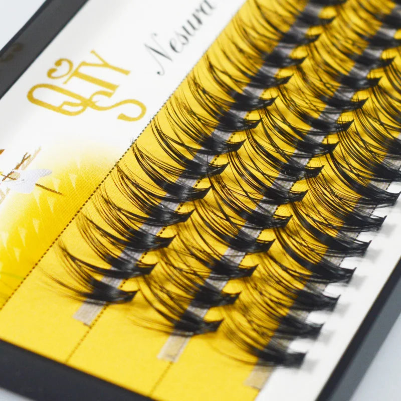 Eyelash extensions on a yellow tray with a brand name on a white background