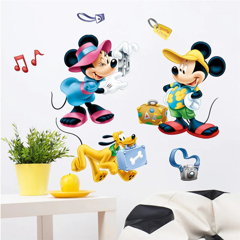 Wall stickers of Mickey Mouse, Minnie Mouse, and Pluto on a white wall with a plant and table in the foreground.