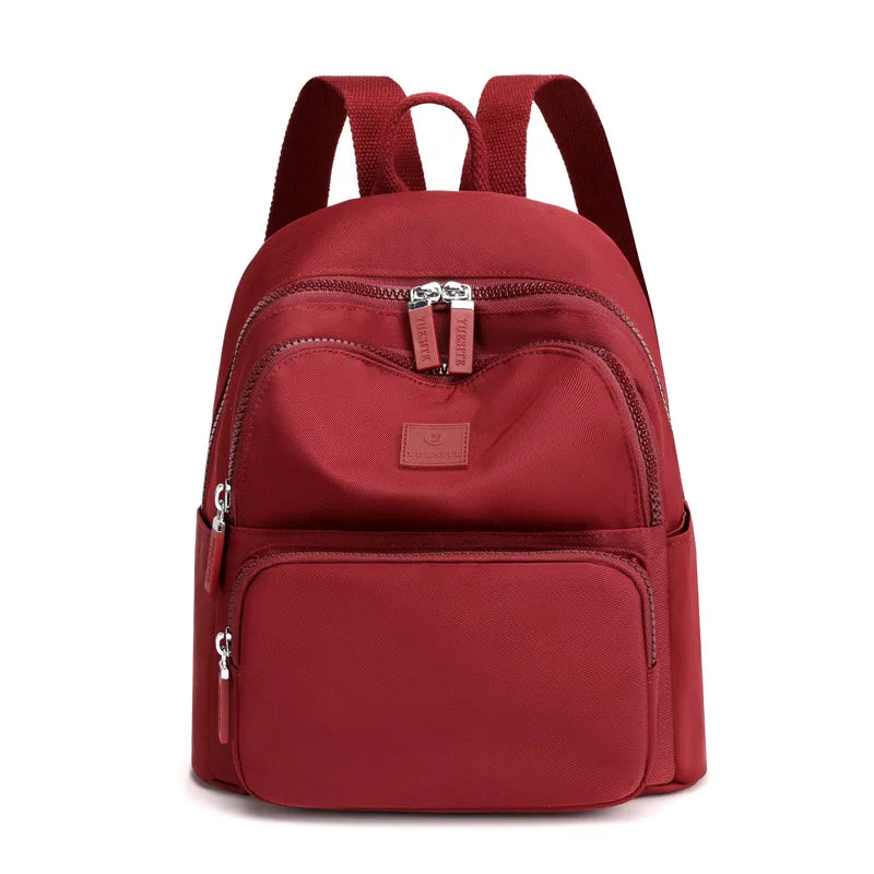 Red backpack with multiple zippers on a white background