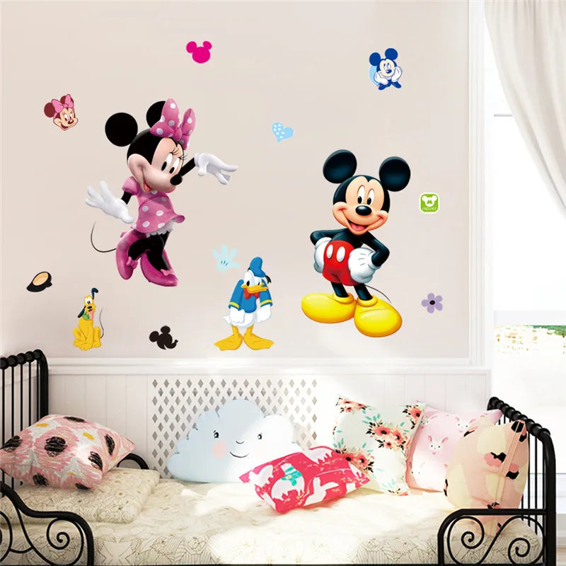 Cartoon character wall decals on a wall with a bed and pillows below.
