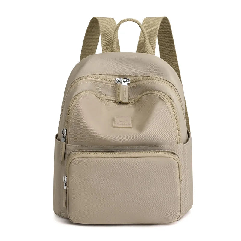 Beige backpack with multiple zippers on a white background