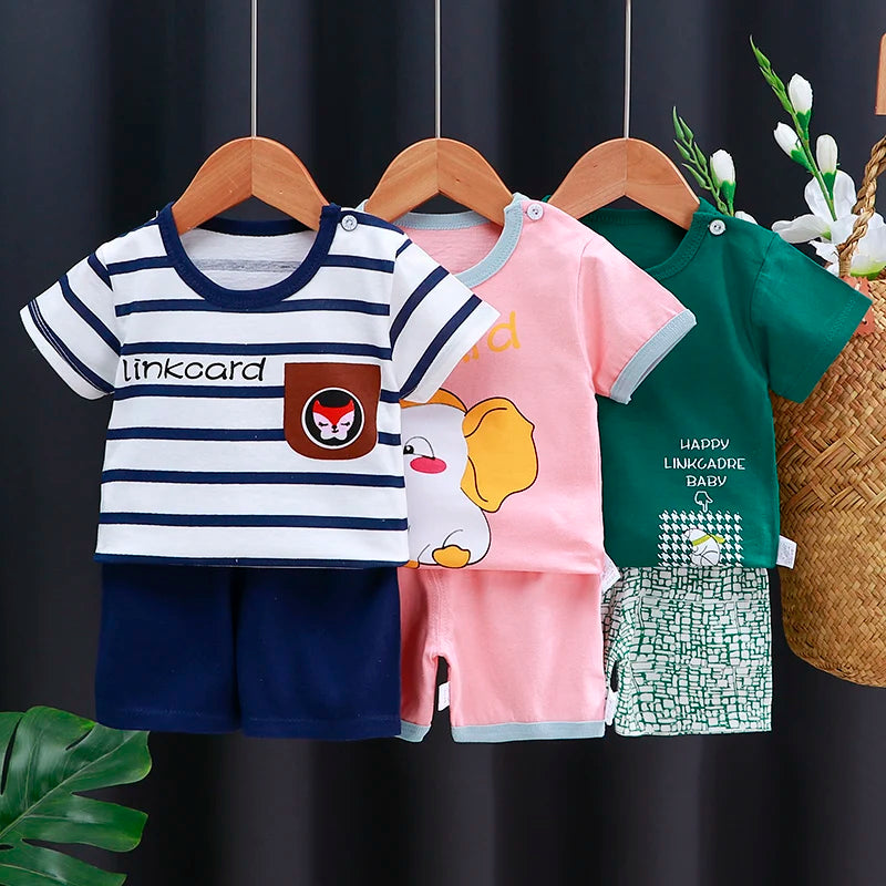 Three children's outfits on hangers against a dark background