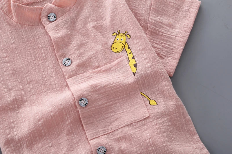 Pink shirt with a cartoon giraffe design on a gray background