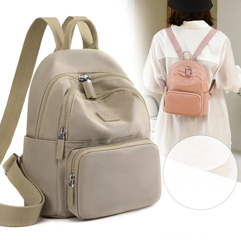 Beige backpack with multiple zippers and a pink backpack worn by a person on a white background.