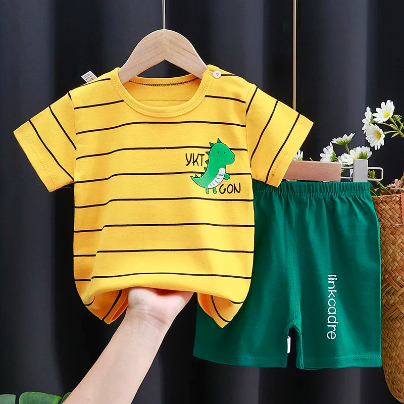 Yellow striped shirt with dinosaur design and green shorts on a hanger against a dark background.