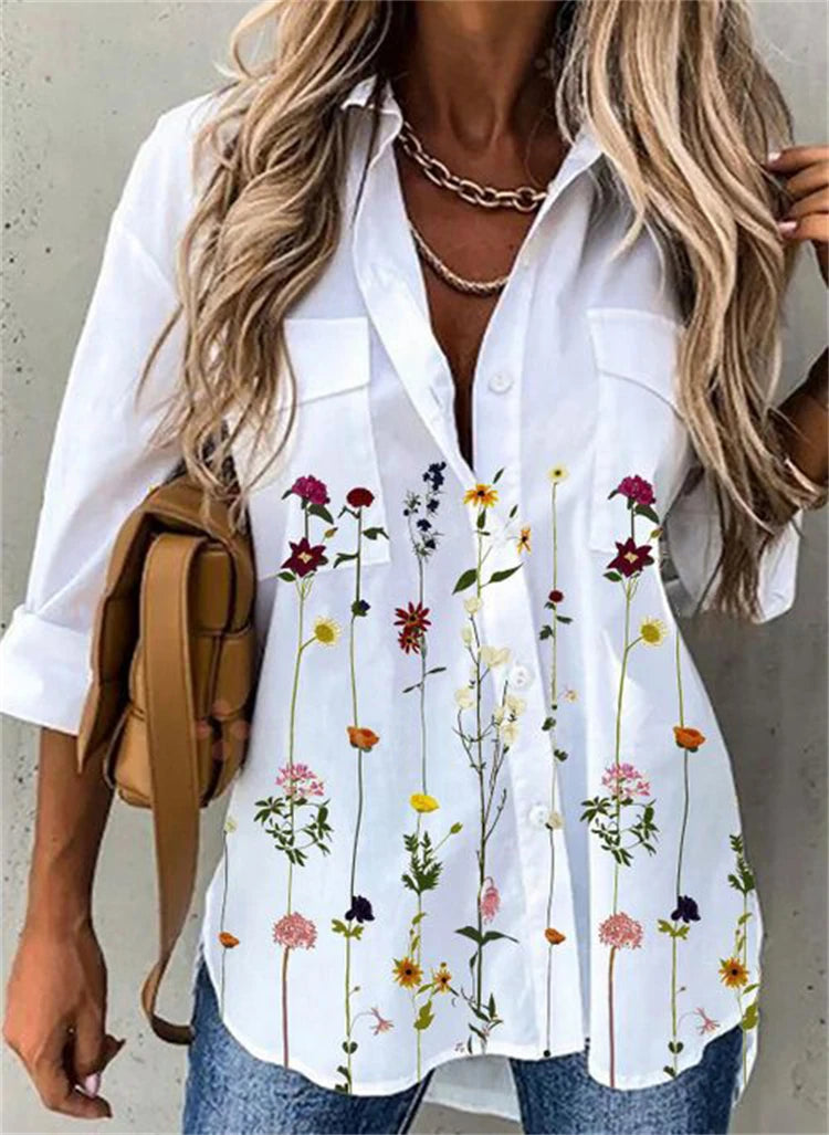 Woman wearing a white blouse with floral patterns, holding a tan backpack.