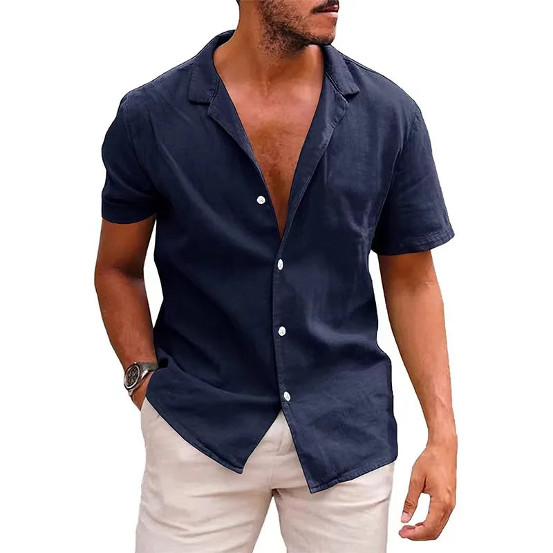 Man wearing a navy blue short-sleeve shirt with white buttons on a white background