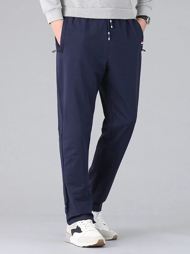 Navy blue pants worn by a person on a gray background