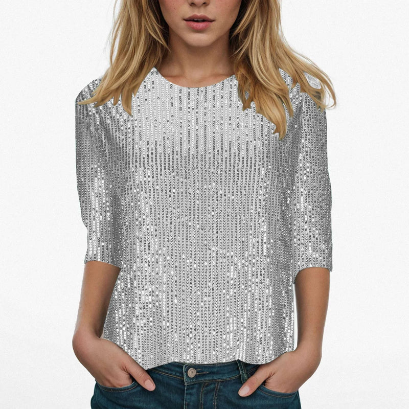 Person wearing a silver sequin top on a white background