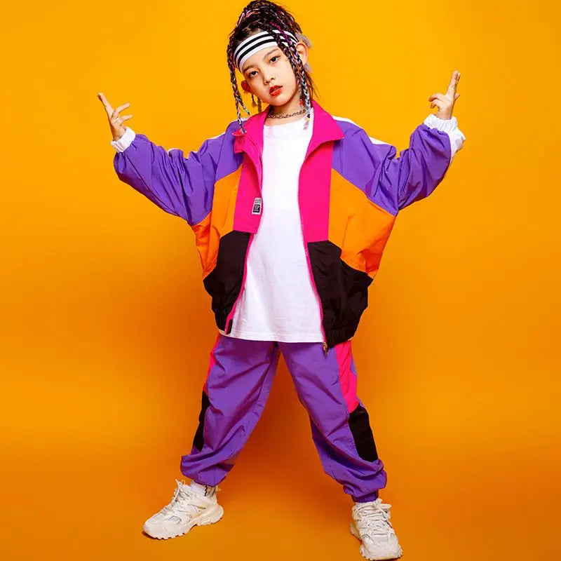 Person wearing a colorful tracksuit against an orange background