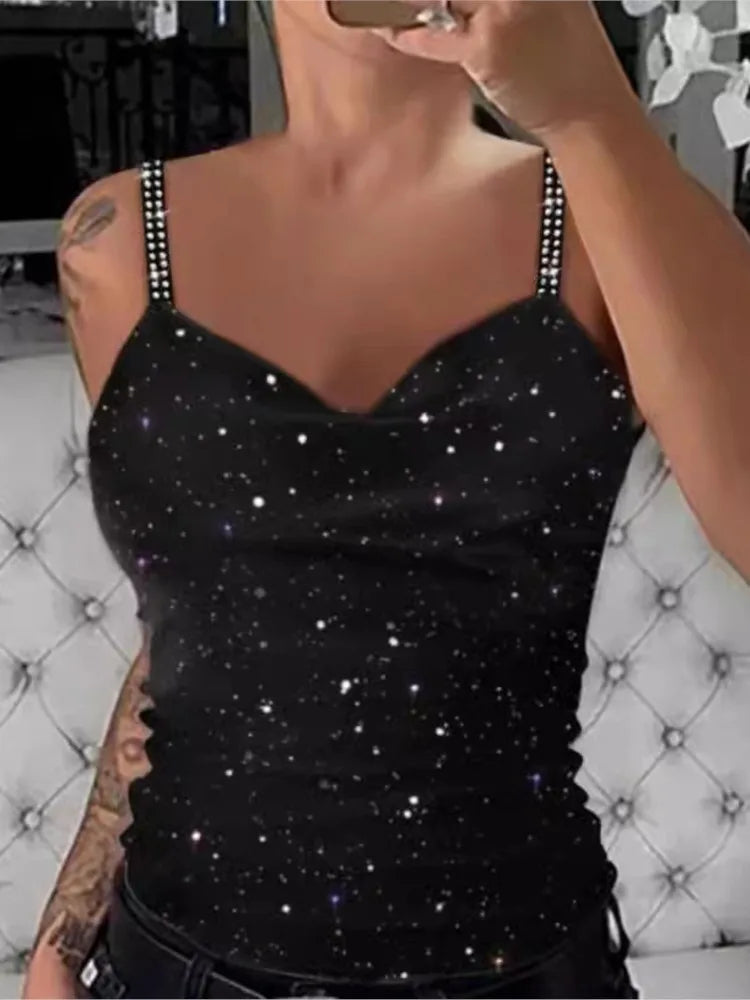 Black tank top with star pattern worn by a person, sitting on a textured chair.