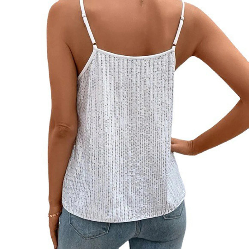 Person wearing a white patterned camisole and blue jeans on a white background