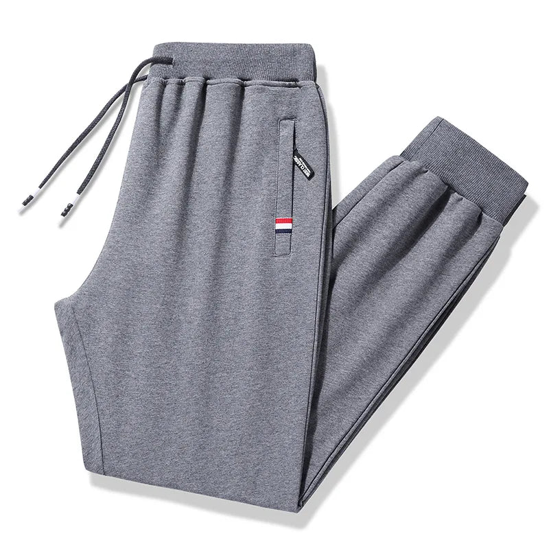 Gray sweatpants with a drawstring and zipper pocket on a white background