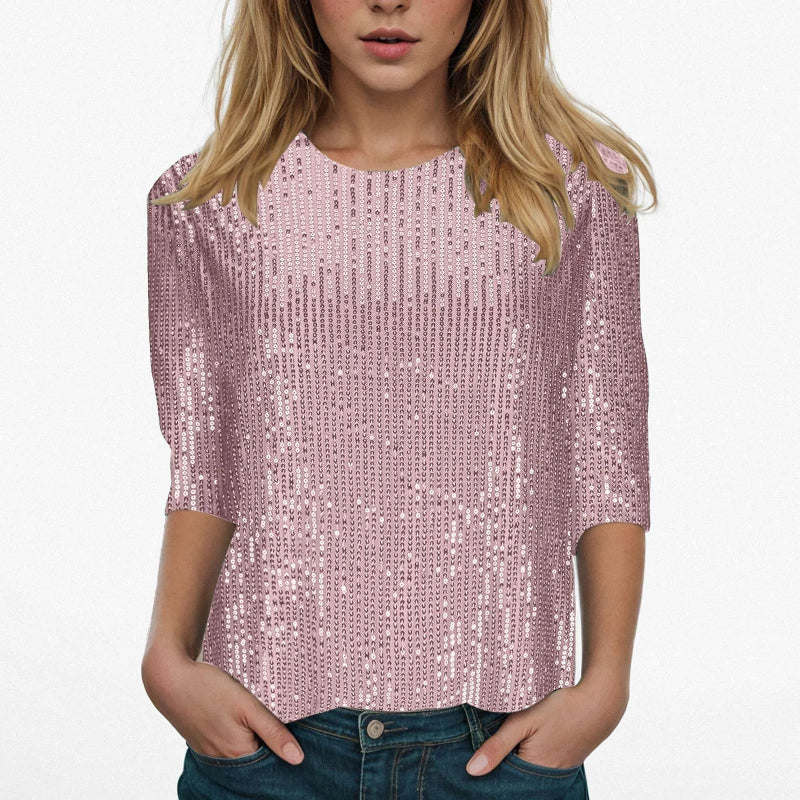 Person wearing a pink sequin top with blue jeans on a white background