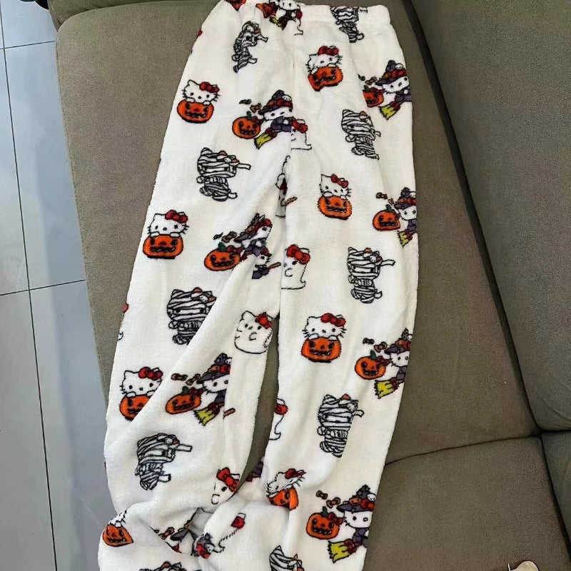White pajama pants with Halloween-themed Hello Kitty design on a brown couch.