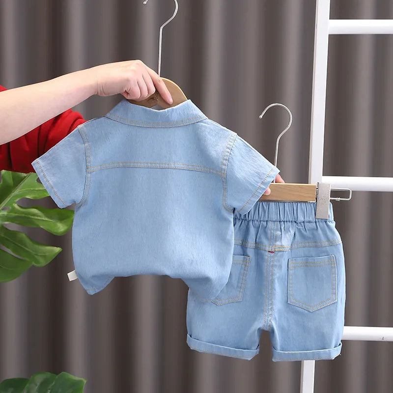 Children's denim outfit on a hanger against a neutral background