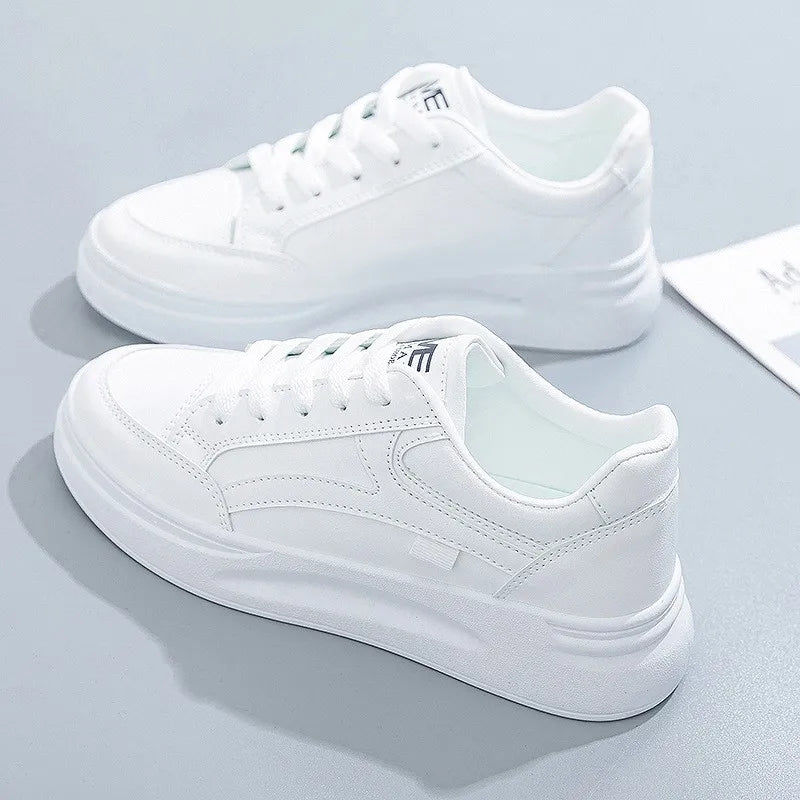 Pair of white sneakers on a light gray background