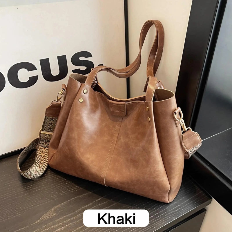 Khaki handbag on a surface with a blurred background