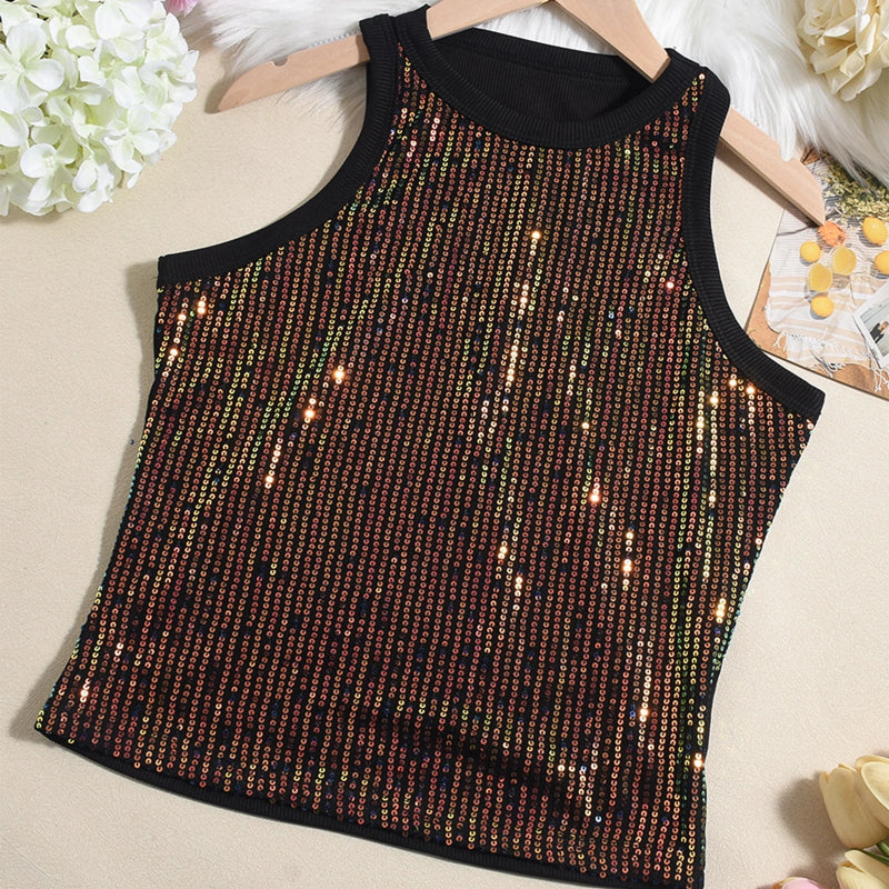 Black sequin tank top on a beige surface with flowers in the background