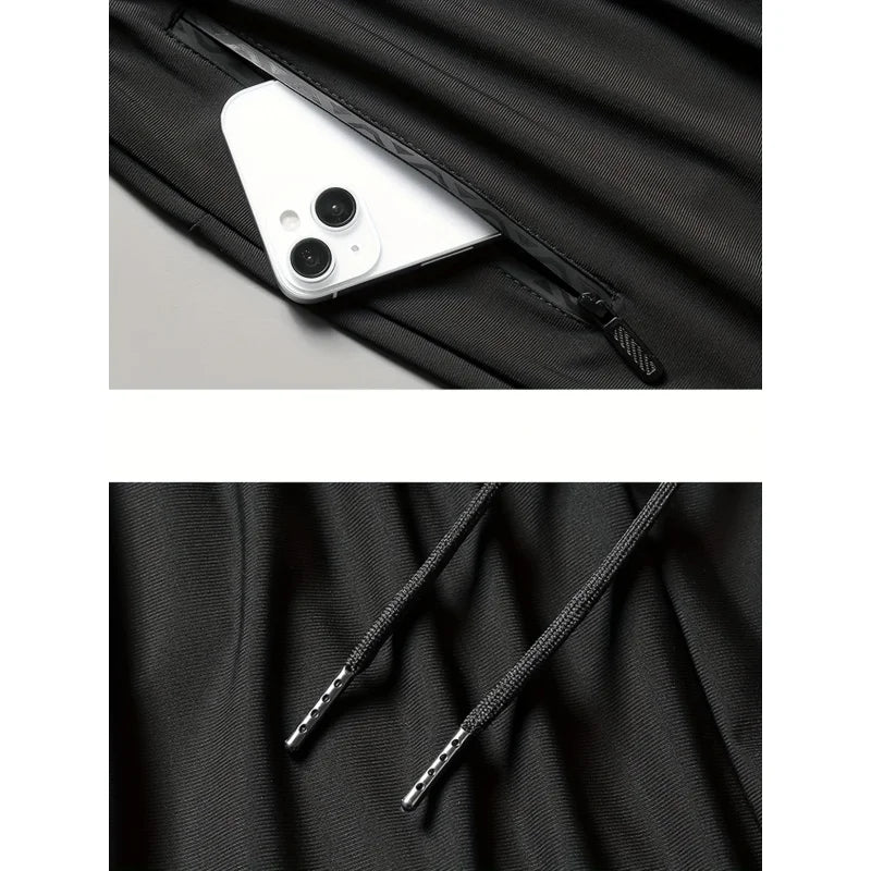 Close-up of a black jacket with a zipper pocket and drawstring, featuring a smartphone inside the pocket.