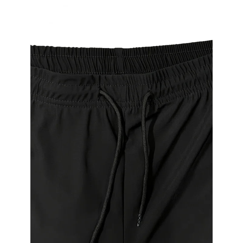 Close-up of black pants with drawstring on a white background