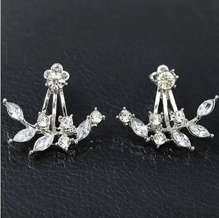 Pair of silver earrings with clear gemstones on a black background