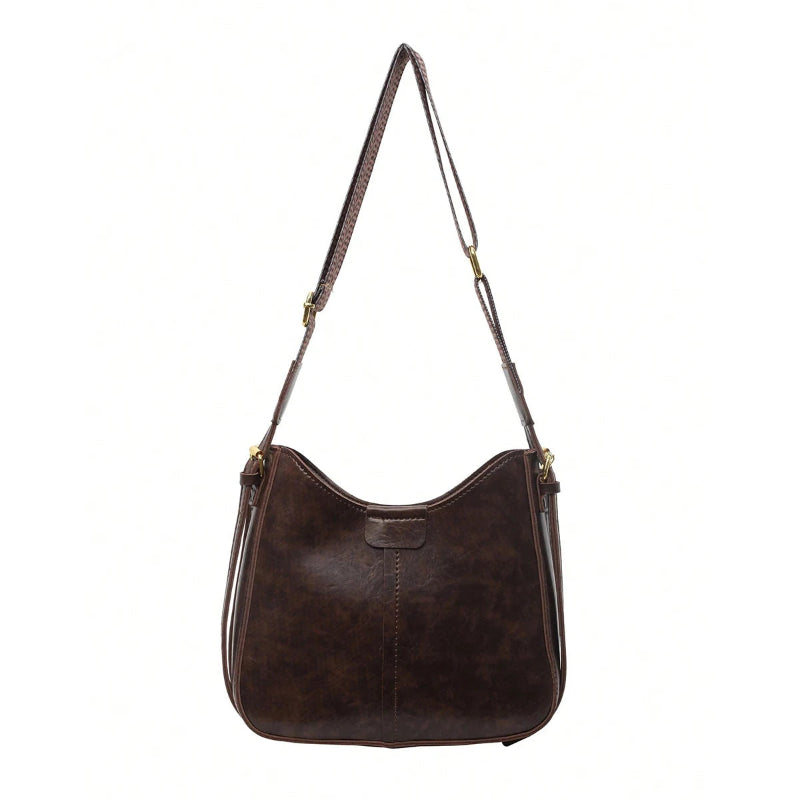 Brown leather handbag with a strap on a white background