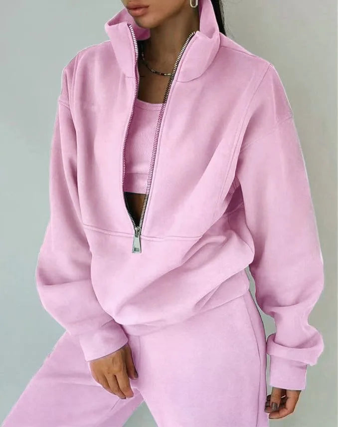 Person wearing a pink tracksuit against a gray background