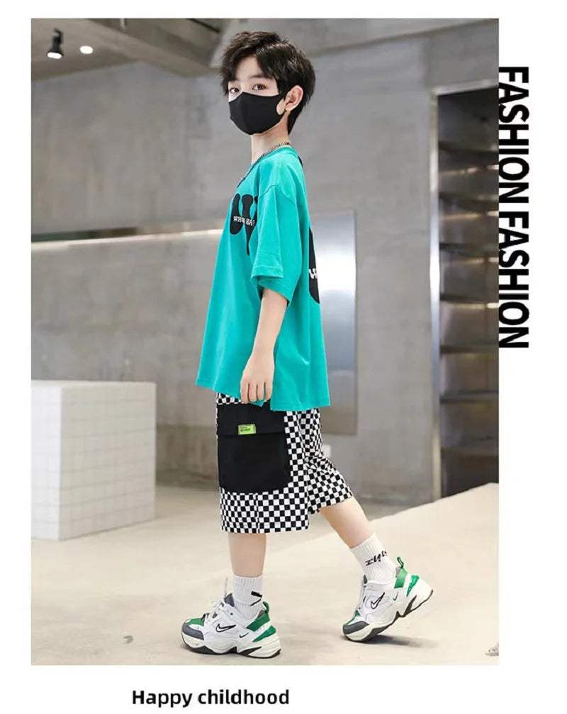 Person wearing a teal shirt, black and white checkered shorts, and green and white sneakers in an indoor setting.