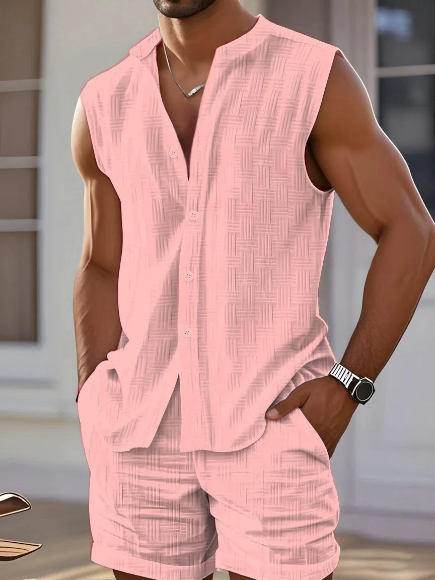 Man wearing a pink sleeveless shirt and shorts set indoors.