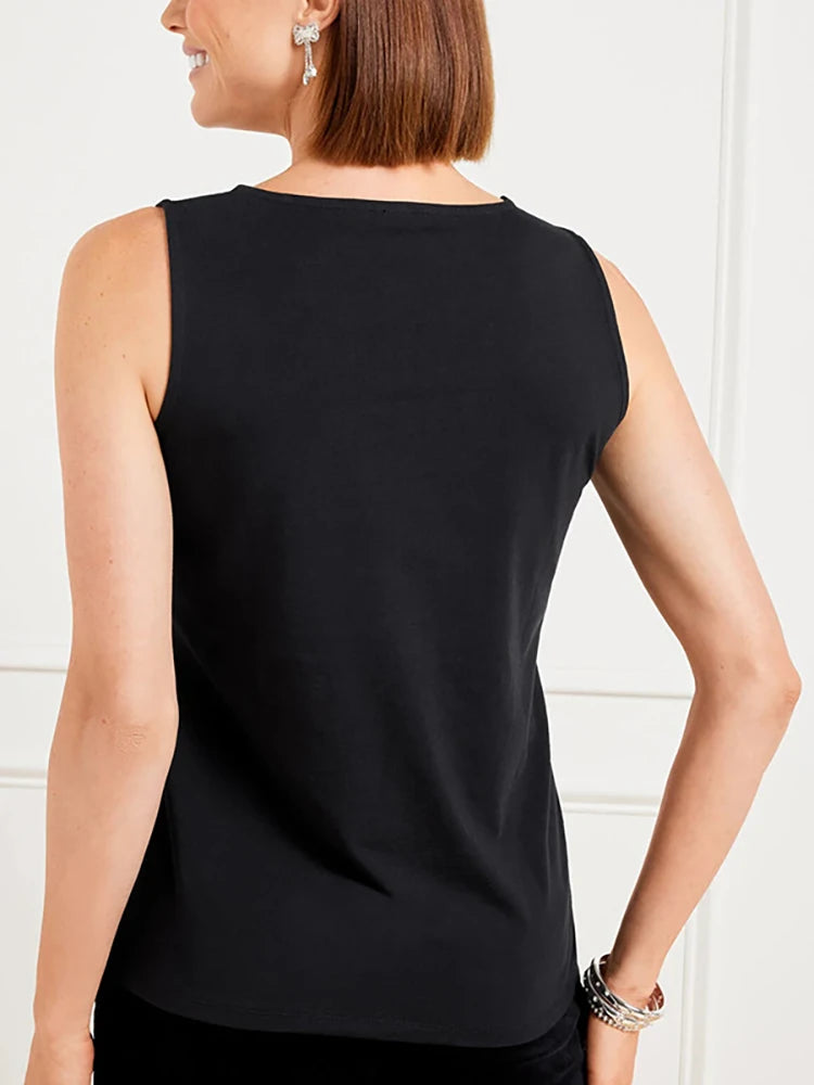Woman wearing a black sleeveless top against a white background