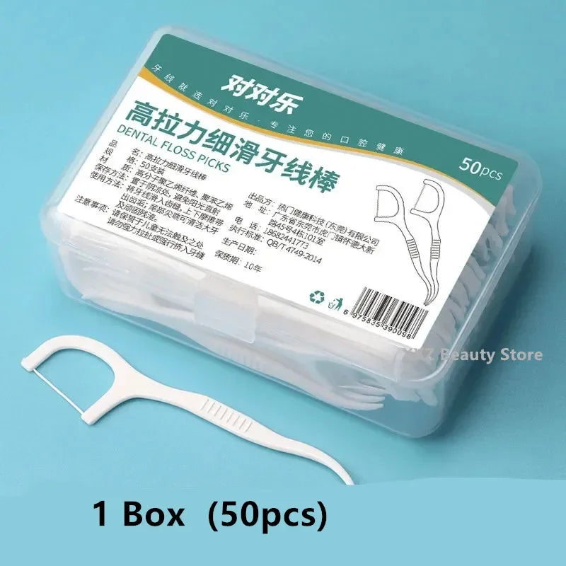 Box of dental floss picks with a single pick in front on a blue background