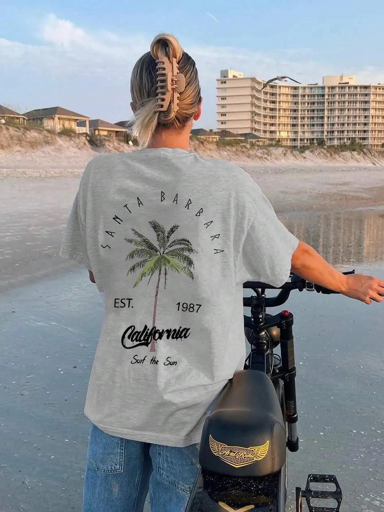 Person wearing a Santa Barbara t-shirt on a beach with palm tree design