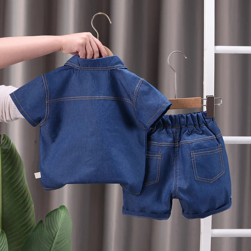 Blue denim jacket and shorts set on hangers against a neutral background