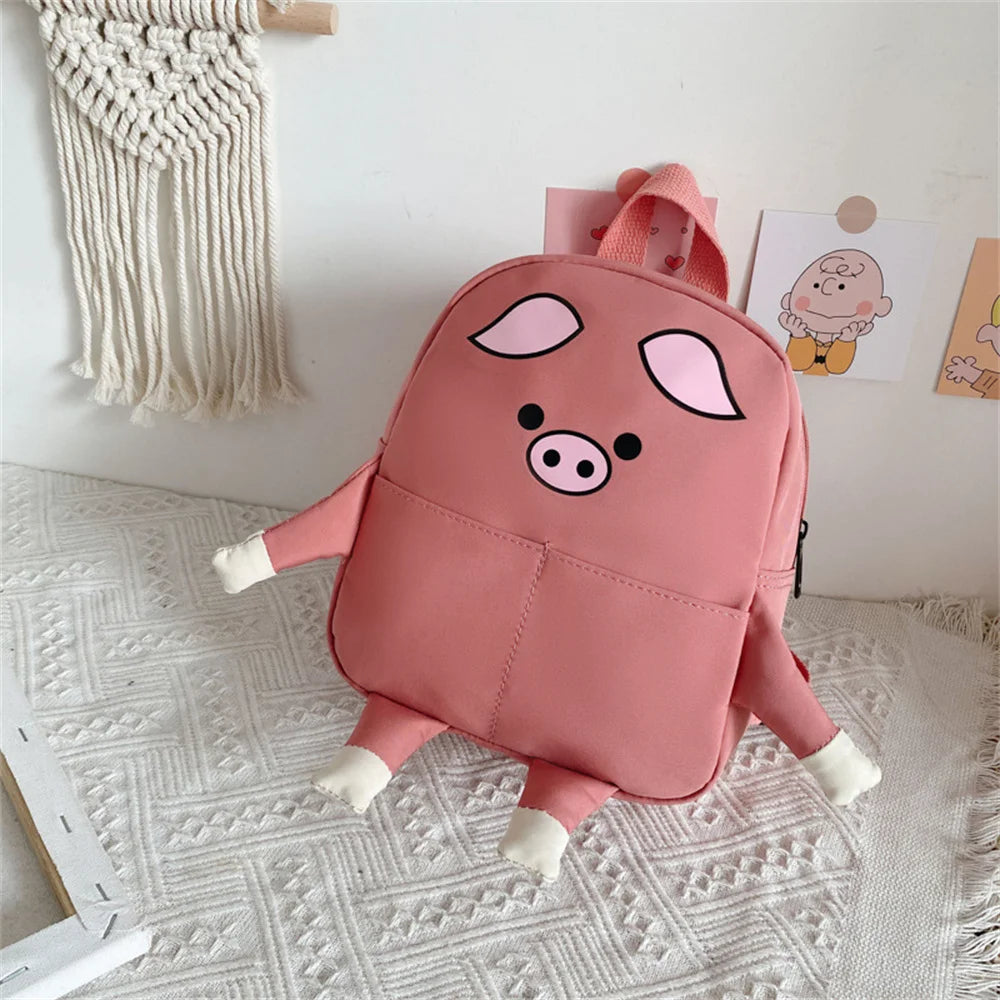 Pink pig-shaped backpack on a textured surface with a white wall in the background