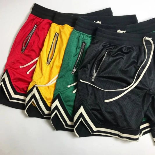 Four pairs of shorts in red, yellow, green, and black on a white background
