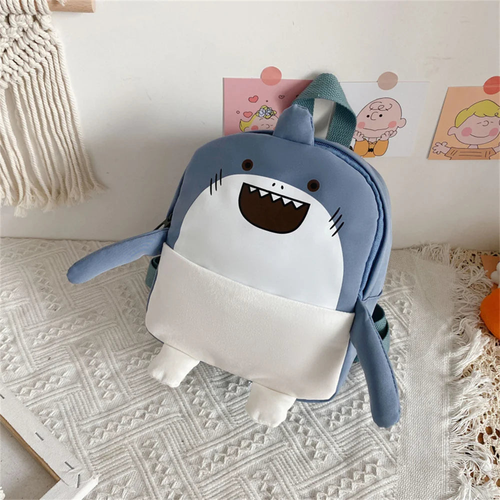 Children's backpack shaped like a shark on a textured surface