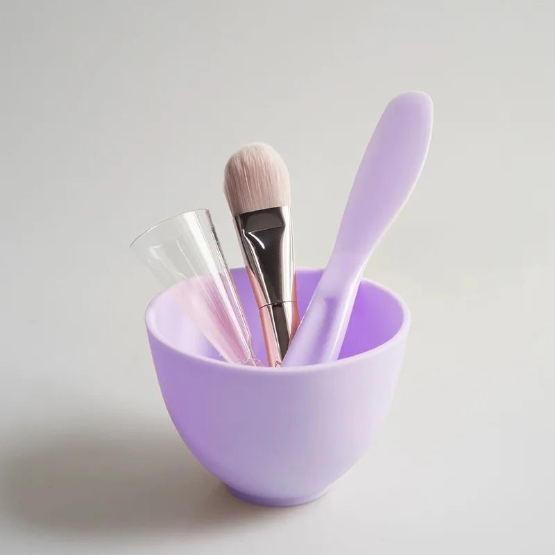Set of makeup brushes in a purple holder on a light gray background