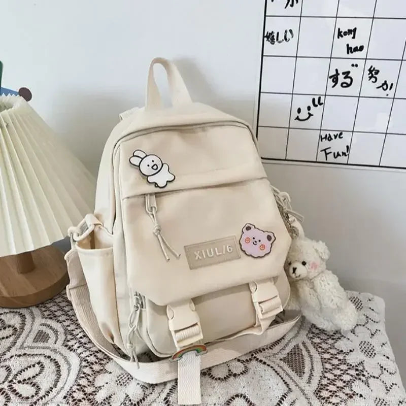 Beige backpack with cute decorations on a textured surface