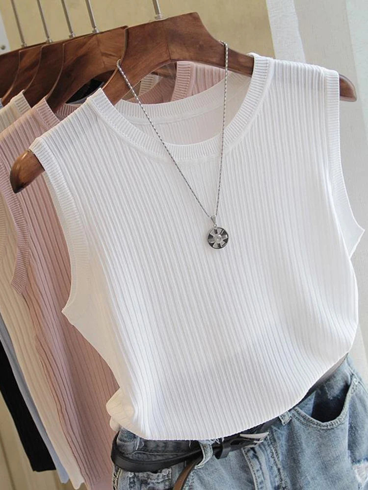 White ribbed tank top on a hanger with a necklace, displayed against a neutral background.