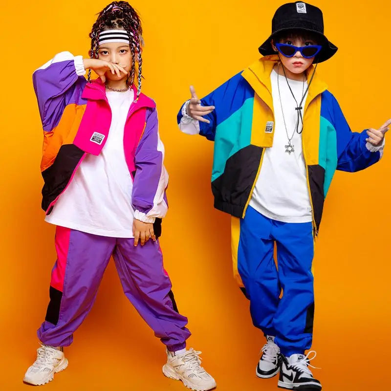 Two individuals wearing colorful, retro-style outfits against an orange background