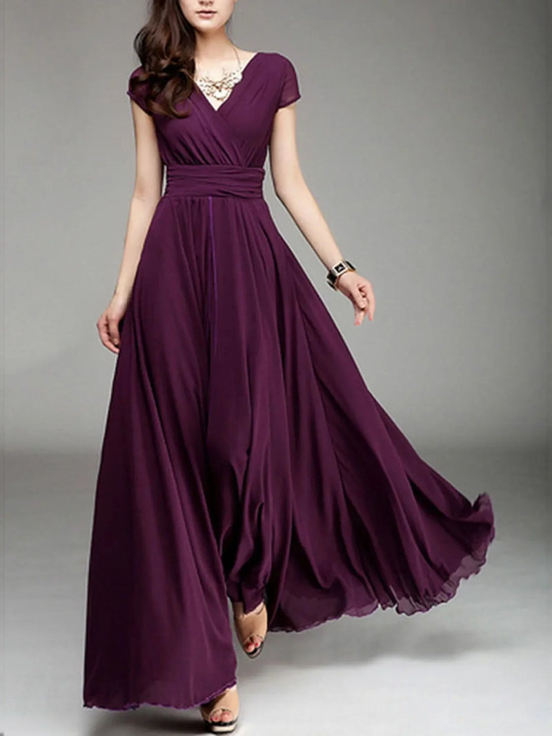 Woman wearing a long purple dress on a gray background