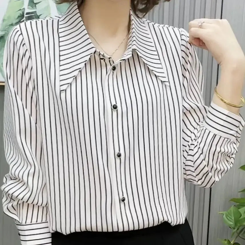 Person wearing a black and white striped shirt with a blurred background