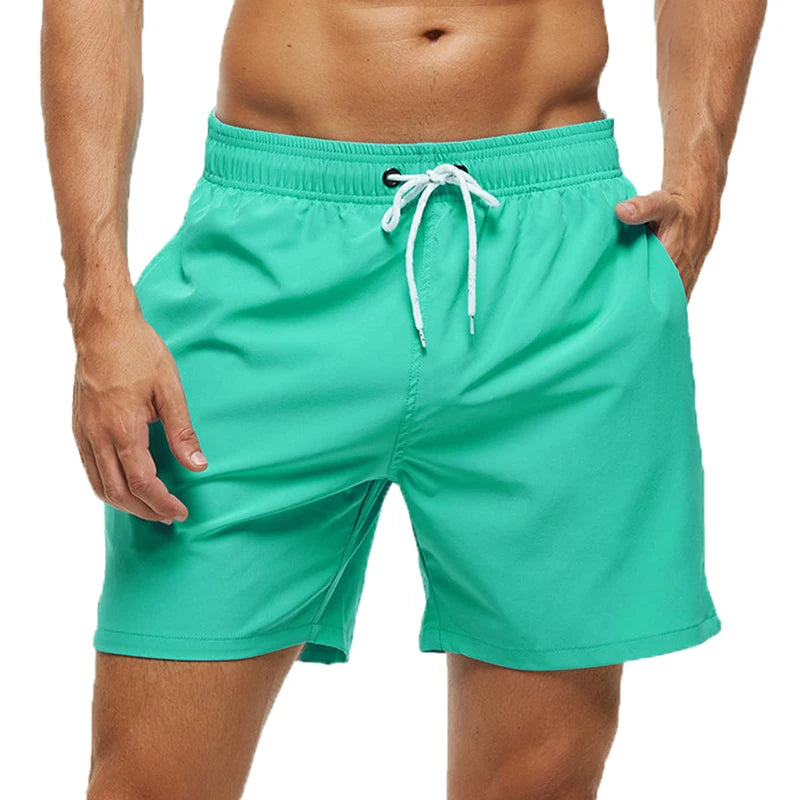 Teal swim shorts with a white drawstring on a white background