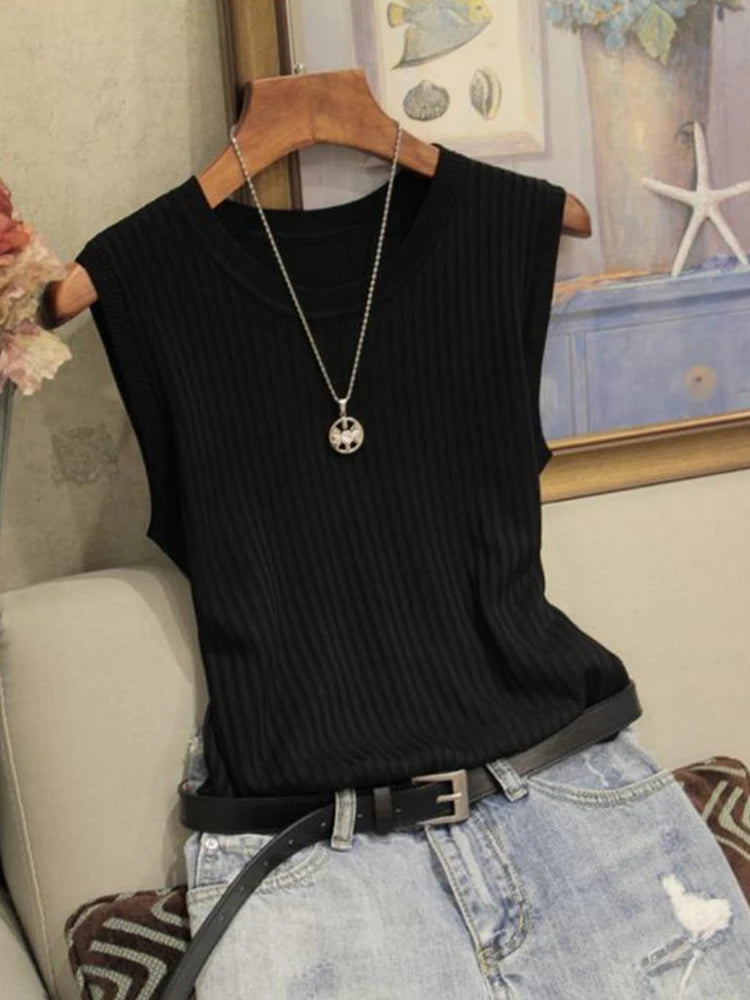 Black ribbed tank top on a hanger with a necklace, worn over light blue jeans.