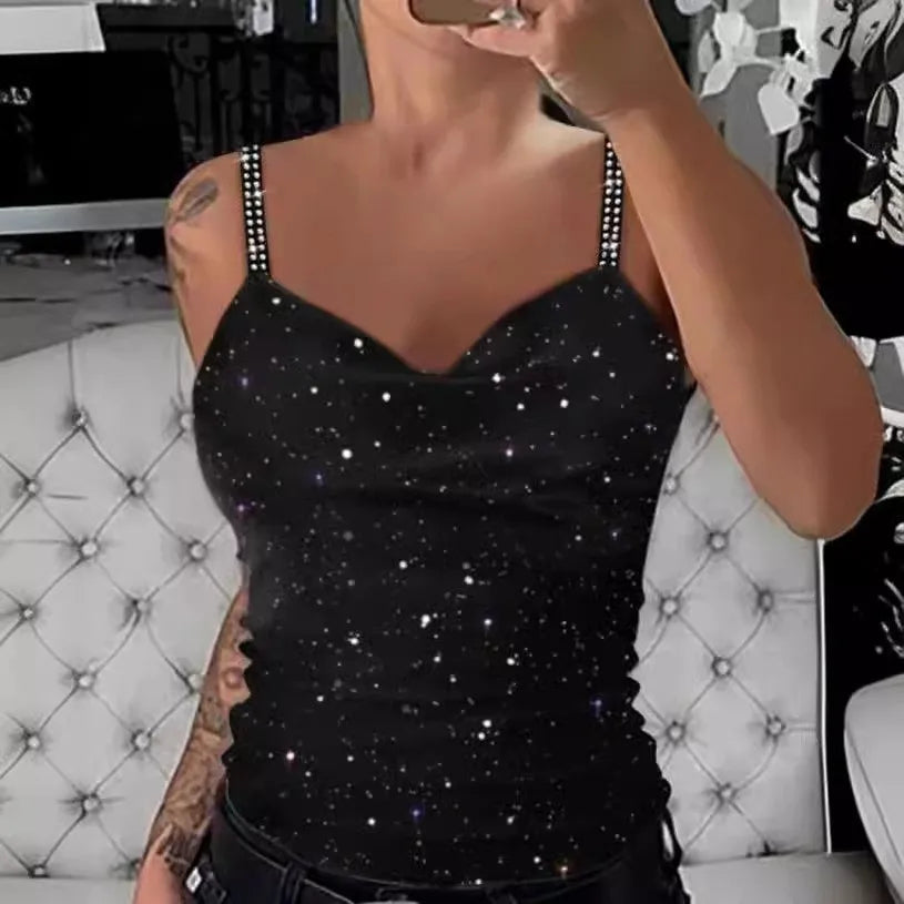 Person wearing a black tank top with star patterns in a room.