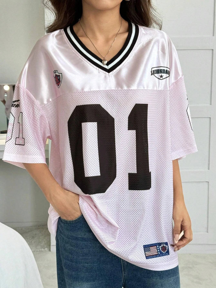 A woman wearing a black V-neck sports jersey with the number '01' on it. The jersey has white text and trim, and it appears to be made of polyester fabric.
