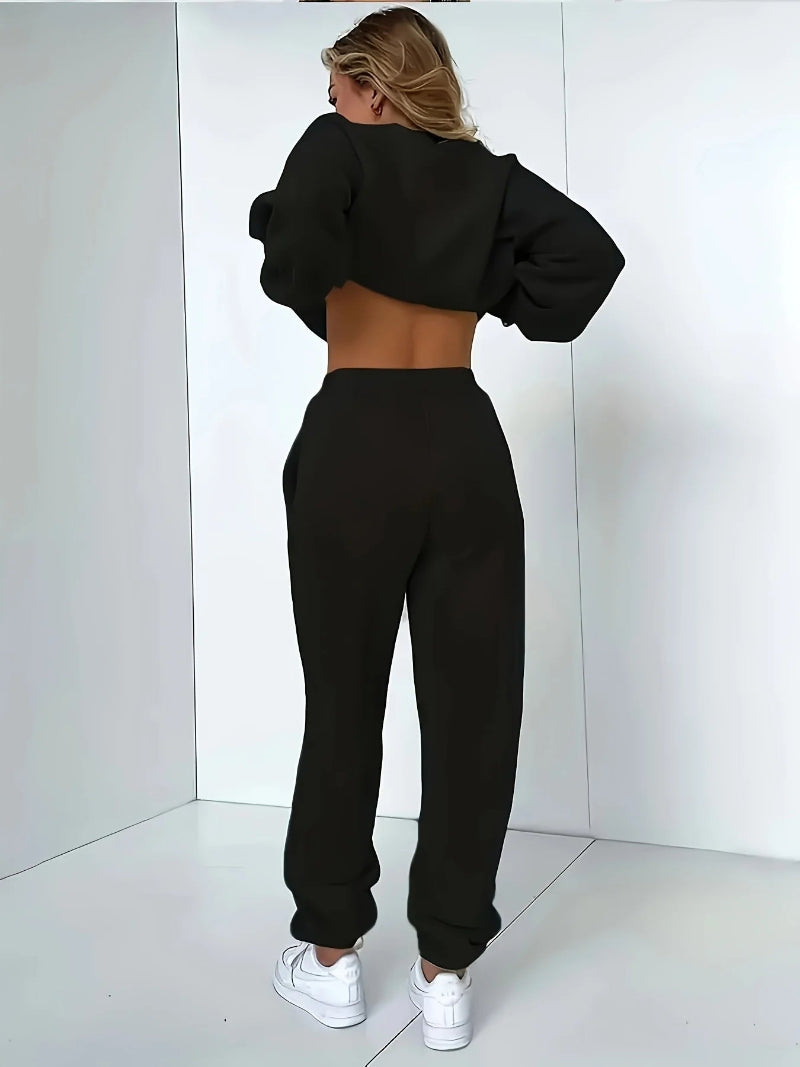Person wearing a black tracksuit against a white background