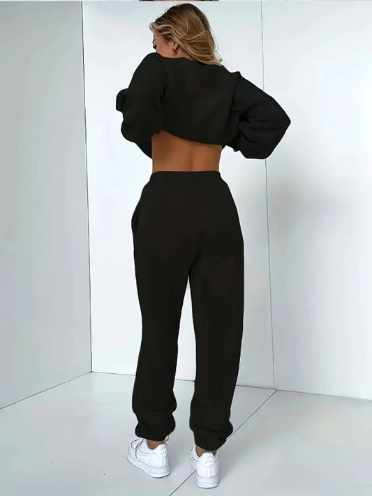 Person wearing a black tracksuit against a white background